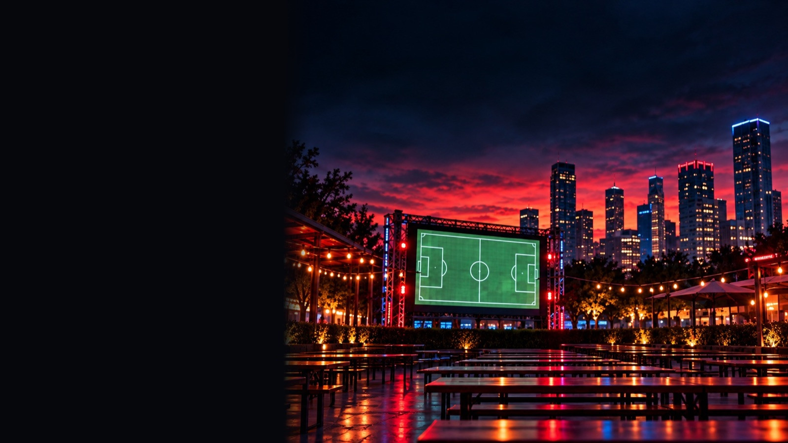 Empty outdoor watch-party tables facing a big screen with a soccer pitch at dusk